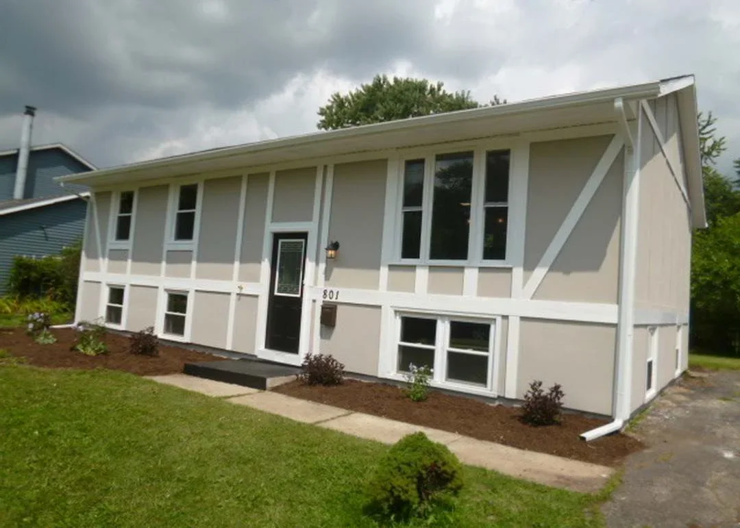 Split-level home with new metal roof, white trim, and updated windows in Oswego